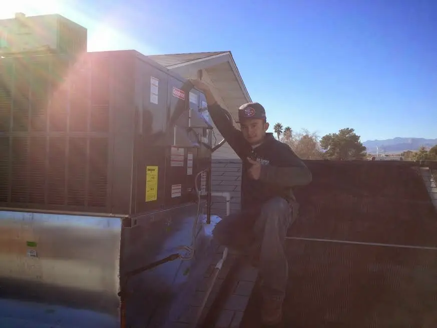 HVAC technician performing Air Duct Cleaning on a rooftop unit in Marshall